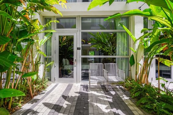 Backyard garden with white metal chairs in Garden Deluxe Double at Fairwind Hotel Miami