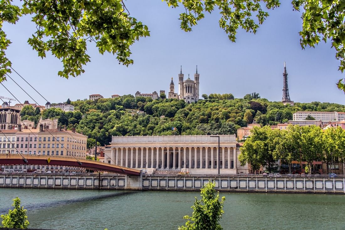 Scenic city view with the Saône River and the grand Palais de Justice under bright skies near Warwick Reine Astrid - Lyon
