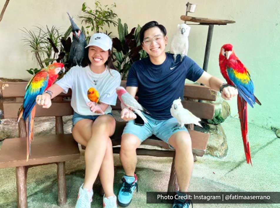 Couple posing with Macaws in KL Bird Park, an entertainment attraction near Imperial Lexis