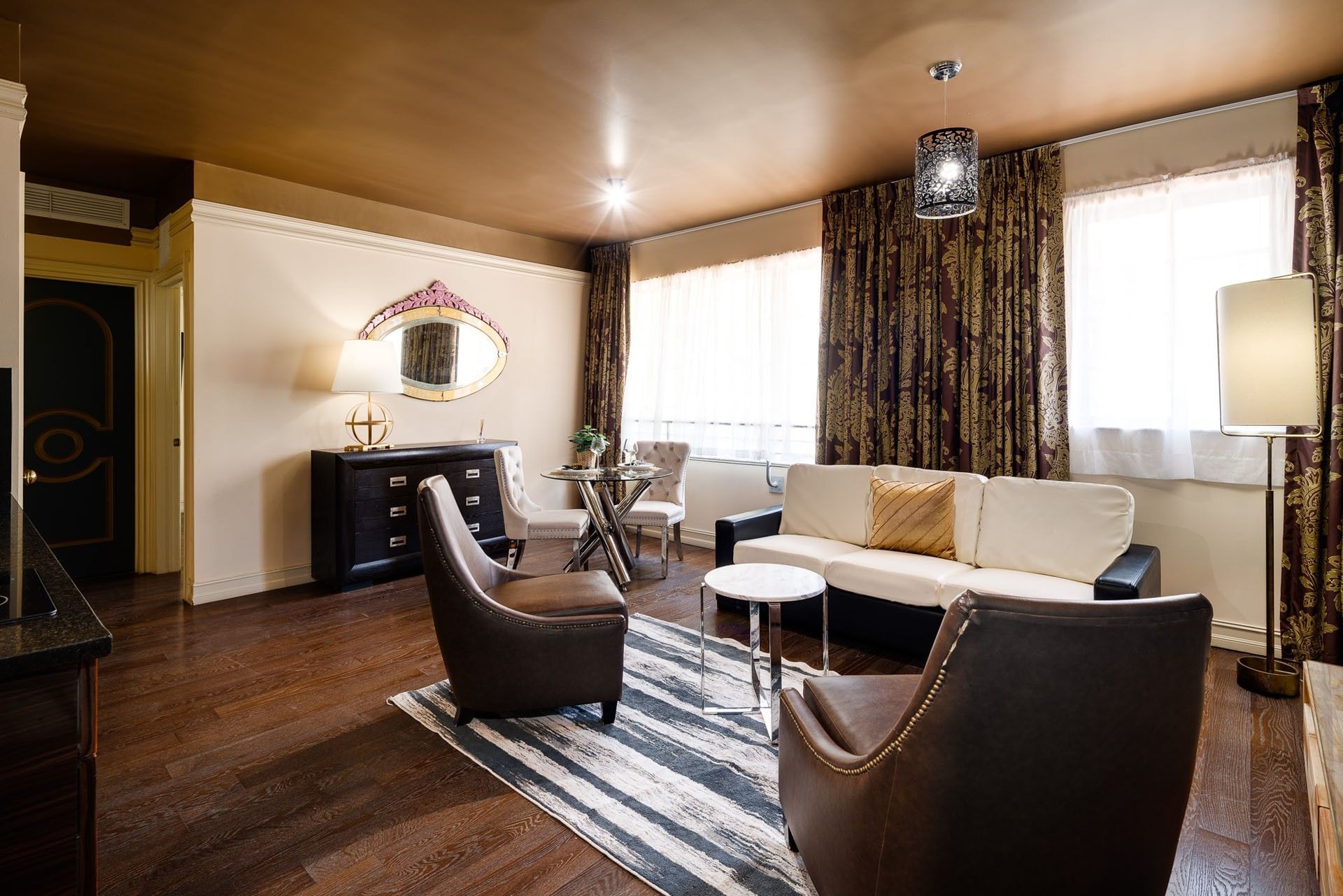 A wide view of a luxurious living room with a sofa, chairs, and a coffee table.