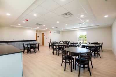 Modern dining area featuring multiple round tables and chairs with wooden flooring at The J Hotel