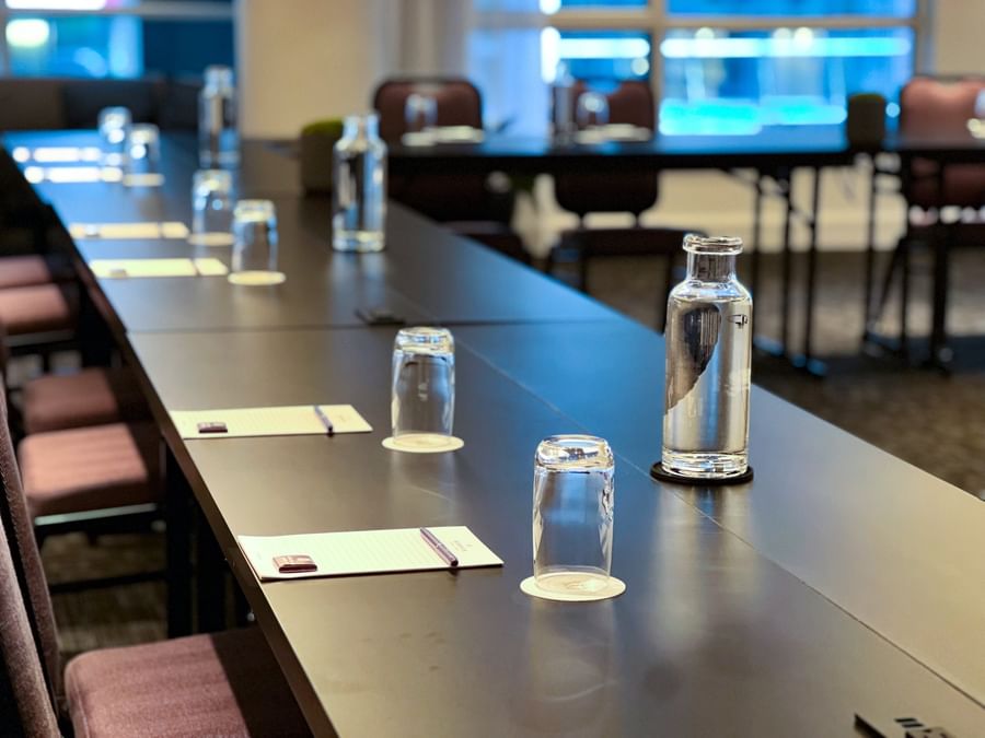 Long conference table with chairs, water bottles, and notepads in Salon Crescent at Warwick Le Crystal Montreal