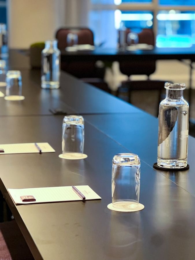 Long conference table with chairs, water bottles, and notepads in Salon Crescent at Warwick Le Crystal Montreal