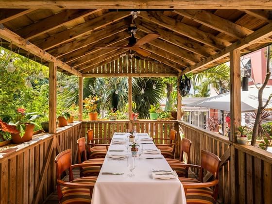 Table arranged in outdoor dining area of Just 24 at Royal Palms Hotel