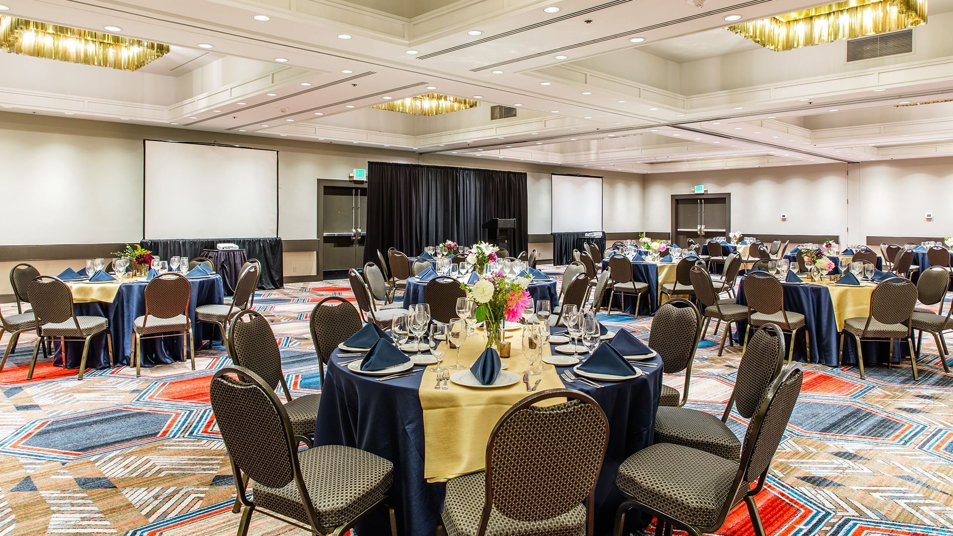 A large meeting room with round tables set for a banquet or event