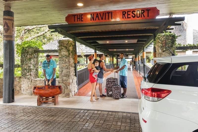 Family with luggage by a staff member near the Car at The Naviti Resort - Fiji