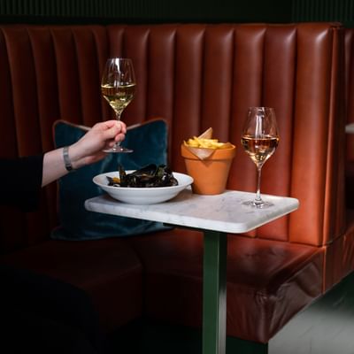 A person raising a wine glass over a table with food at The Sparrow Hotel
