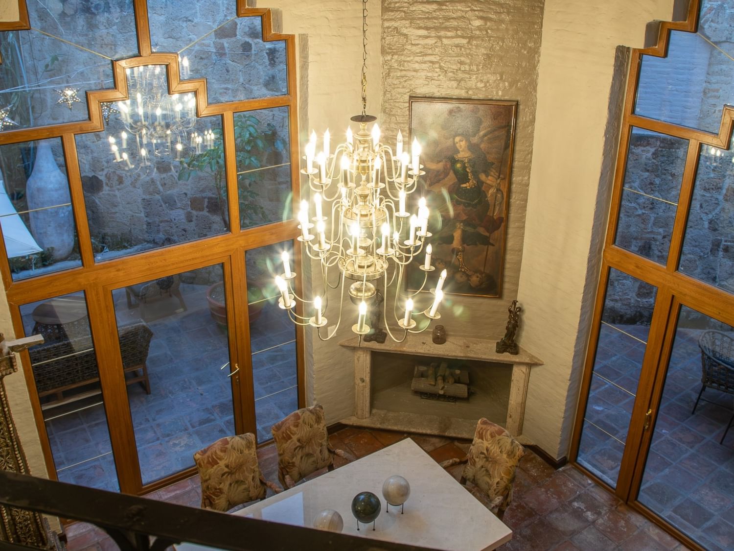 Vista aérea de Suite Presidencial King con candelabro elegante y ventanas de diseño geométrico en Quinta Real Guadalajara