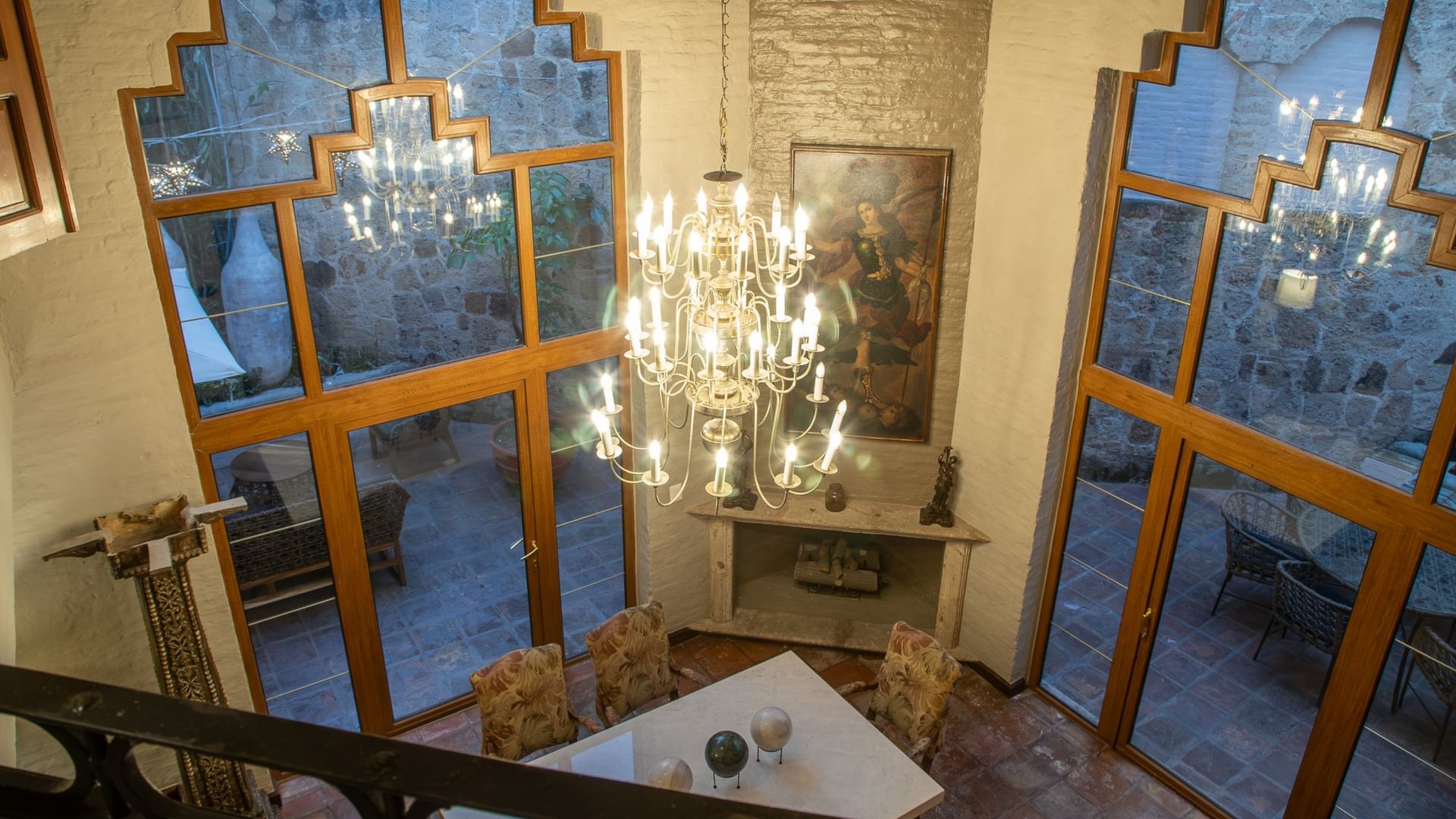 Vista aérea de Suite Presidencial King con candelabro elegante y ventanas de diseño geométrico en Quinta Real Guadalajara