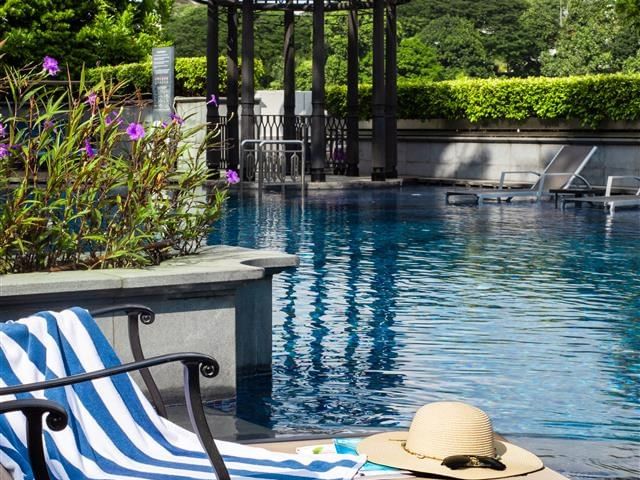 Outdoor pool with lounge chairs and gazebo promoting Summer Getaway Offer.