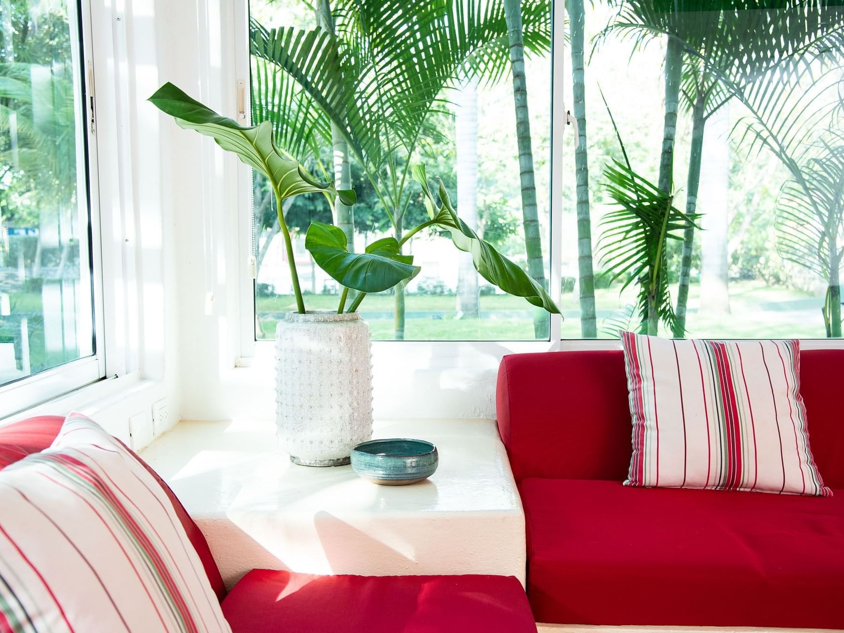 Red couch and a potted plant in the living area of Double Twin Room at Villas Codevi