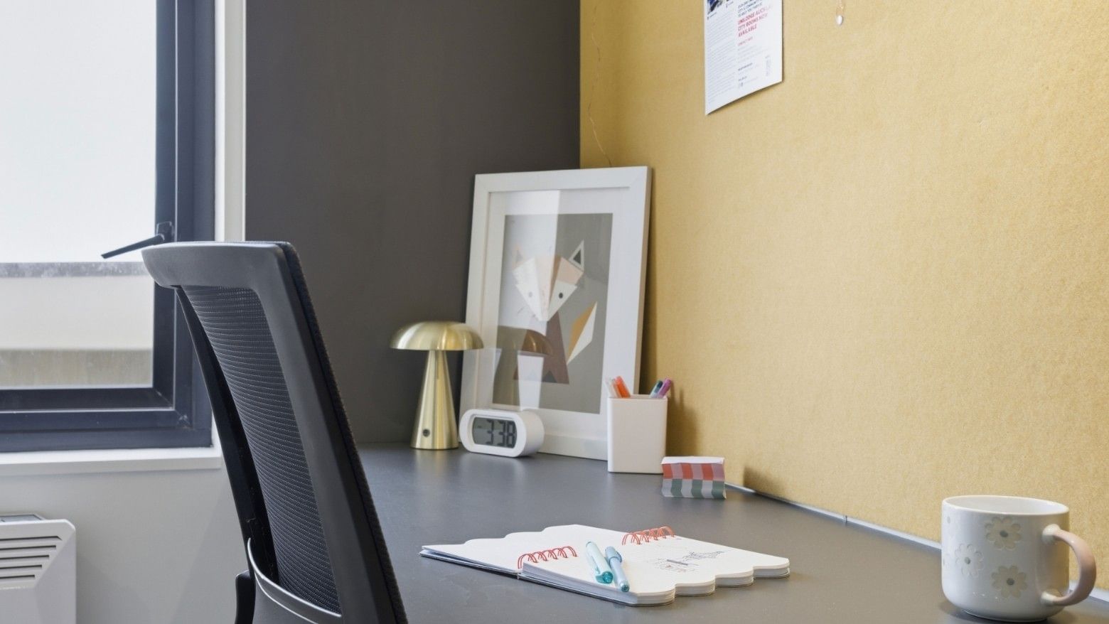 Office area with desk, chair, framed picture, and supplies at UniLodge Auckland City.