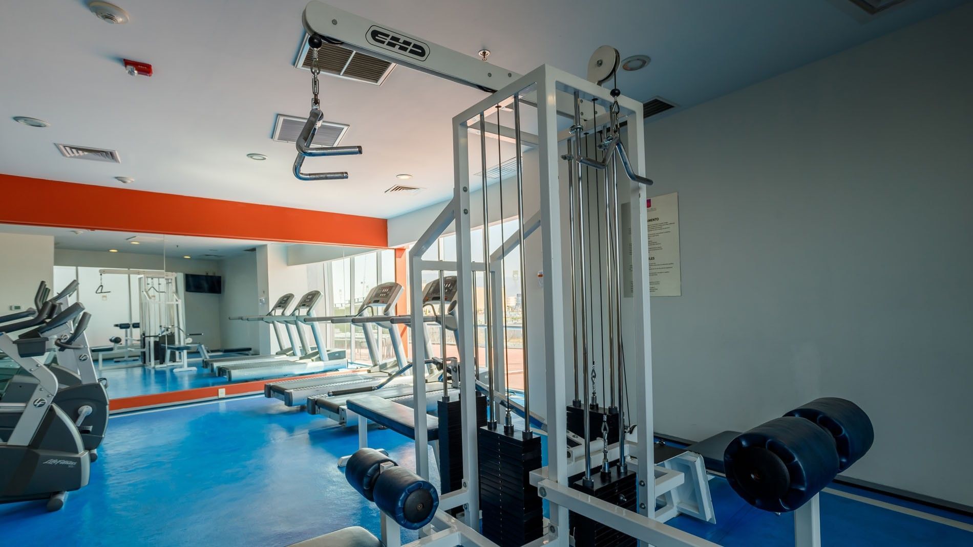 Strength training equipment and weight machines near the cardio area at Camino Real Pachuca