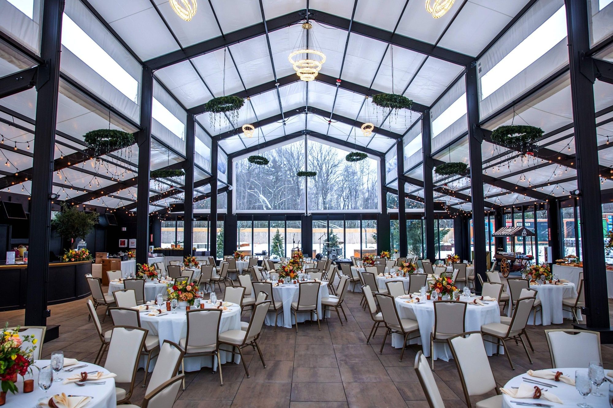 The Secret Garden Brunch with chandelier lights over round dining tables set for a banquet reception at The Brook