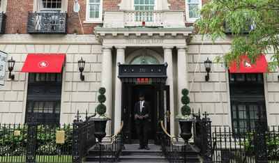 A doorman standing at the entrance of The Eliot Hotel