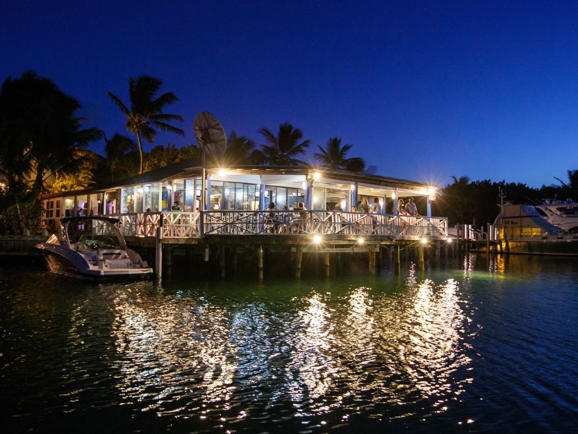 People dining on a deck in the Sharkbite Bar and Grill at Zenza Hotel