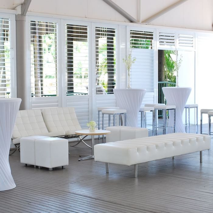 Plantation Deck featuring white furniture, tall cocktail tables, and decorative vases at Mercure Hotel Townsville