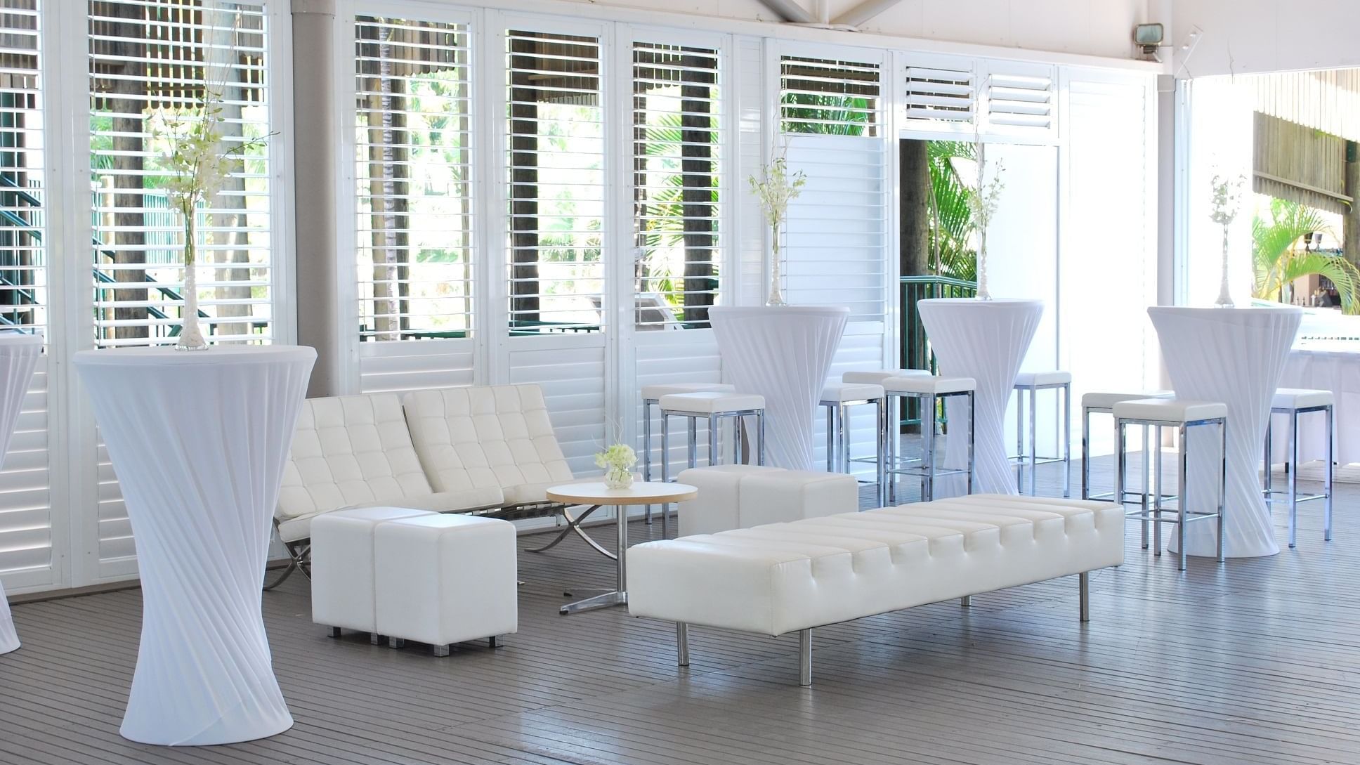 Plantation Deck featuring white furniture, tall cocktail tables, and decorative vases at Mercure Hotel Townsville