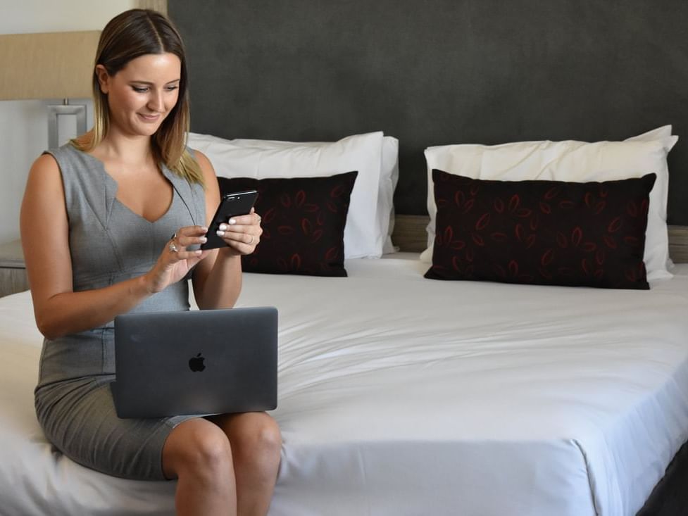 A girl using her phone in a room at H On Smith Hotel