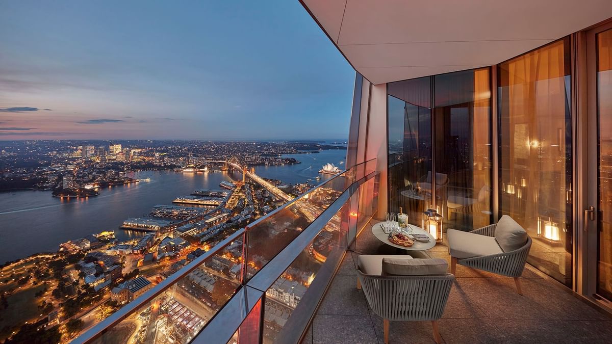 Harbour Villa balcony view with outdoor furniture overlooking a lit-up cityscape at Crown Hotels