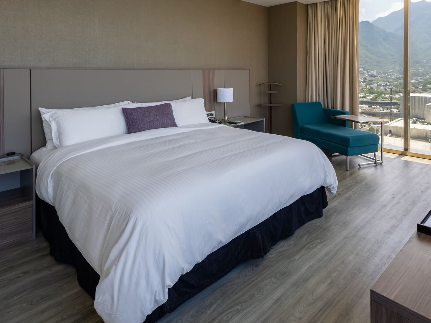 King Junior Suite with mountain views, modern furnishings, and seating area at Camino Real Fashion Drive Monterrey.
