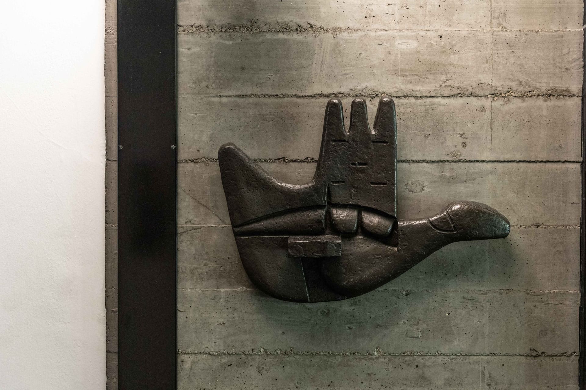 Scultura la main ouverte di Le Corbusier su muro di cemento di DUPARC Contemporary Suites