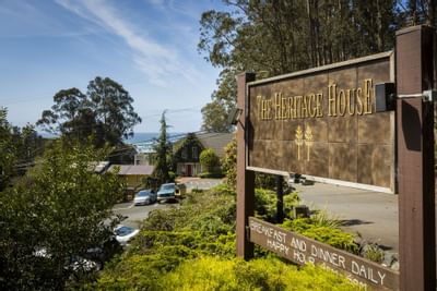 Name board of Heritage House Resort placed infront of the hotel