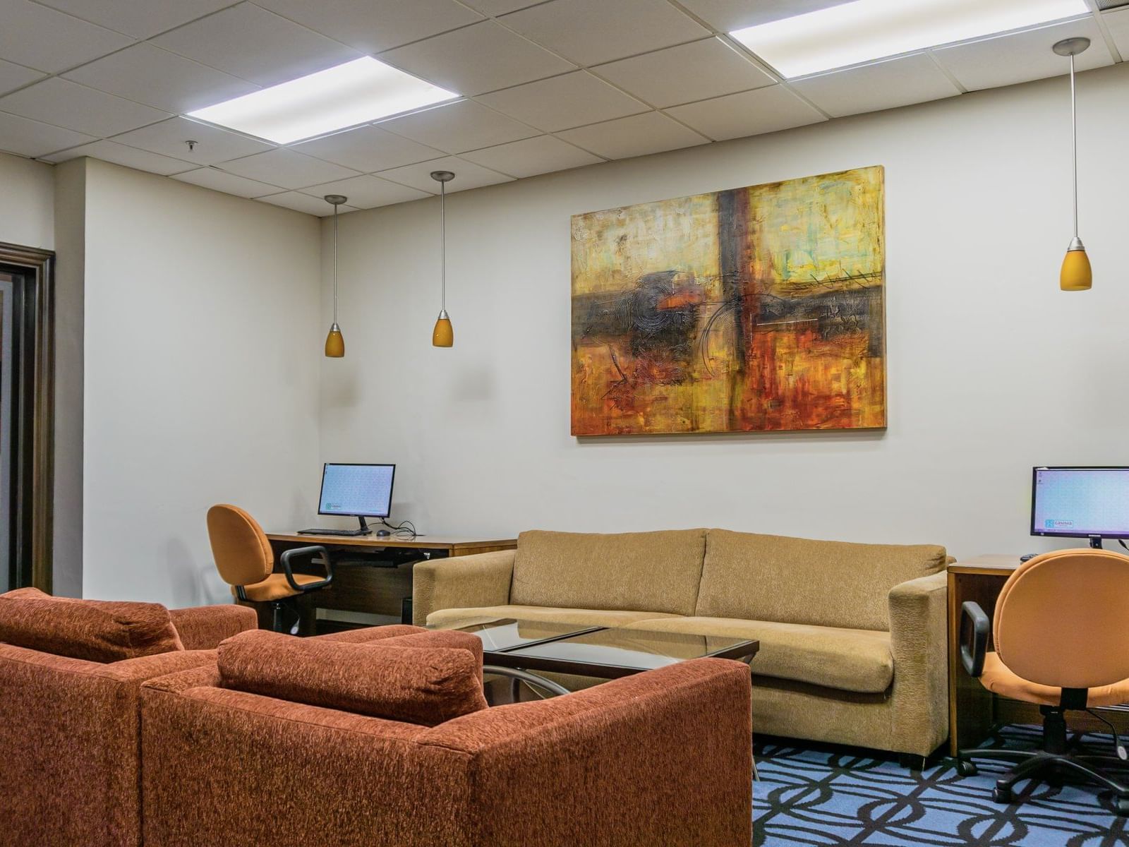 Sofas & computers in the business center at Gamma Hotels