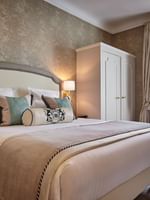 Élégante chambre Deluxe avec un grand lit, du papier peint à motifs et une vue sur Paris à l'Hôtel Westminster - Paris.