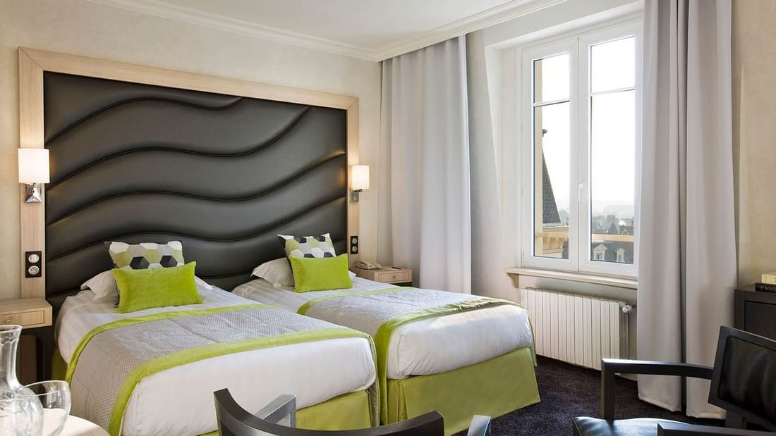 Two beds with a cushioned headboard in Escale Superieure at Le Grand Hôtel des Thermes