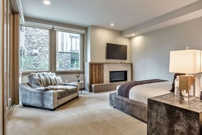 Bedroom with a king bed featuring TV & fireplace at Stein Eriksen Residences