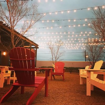 adirondack chairs set in circle under string lights