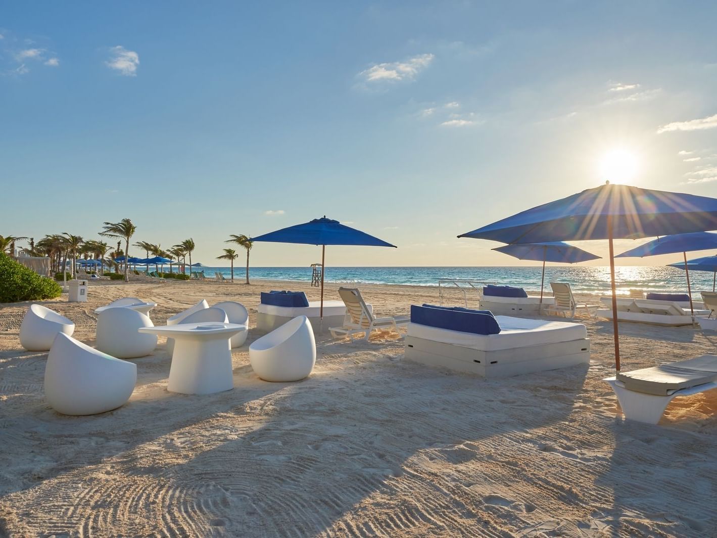 Beach with lounge chairs at sunset at the La Colección Resorts 