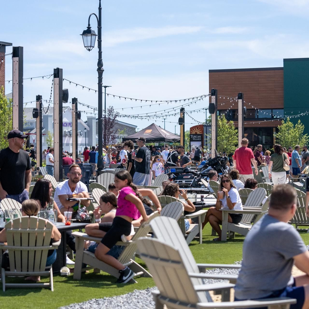 People lounging & enjoying in the Beer Garden on a sunny day near The Artisan Hotel at Tuscan Village