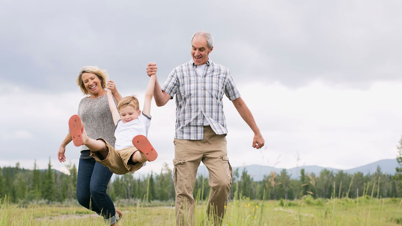 Grandparents with grandchildren playing in the field