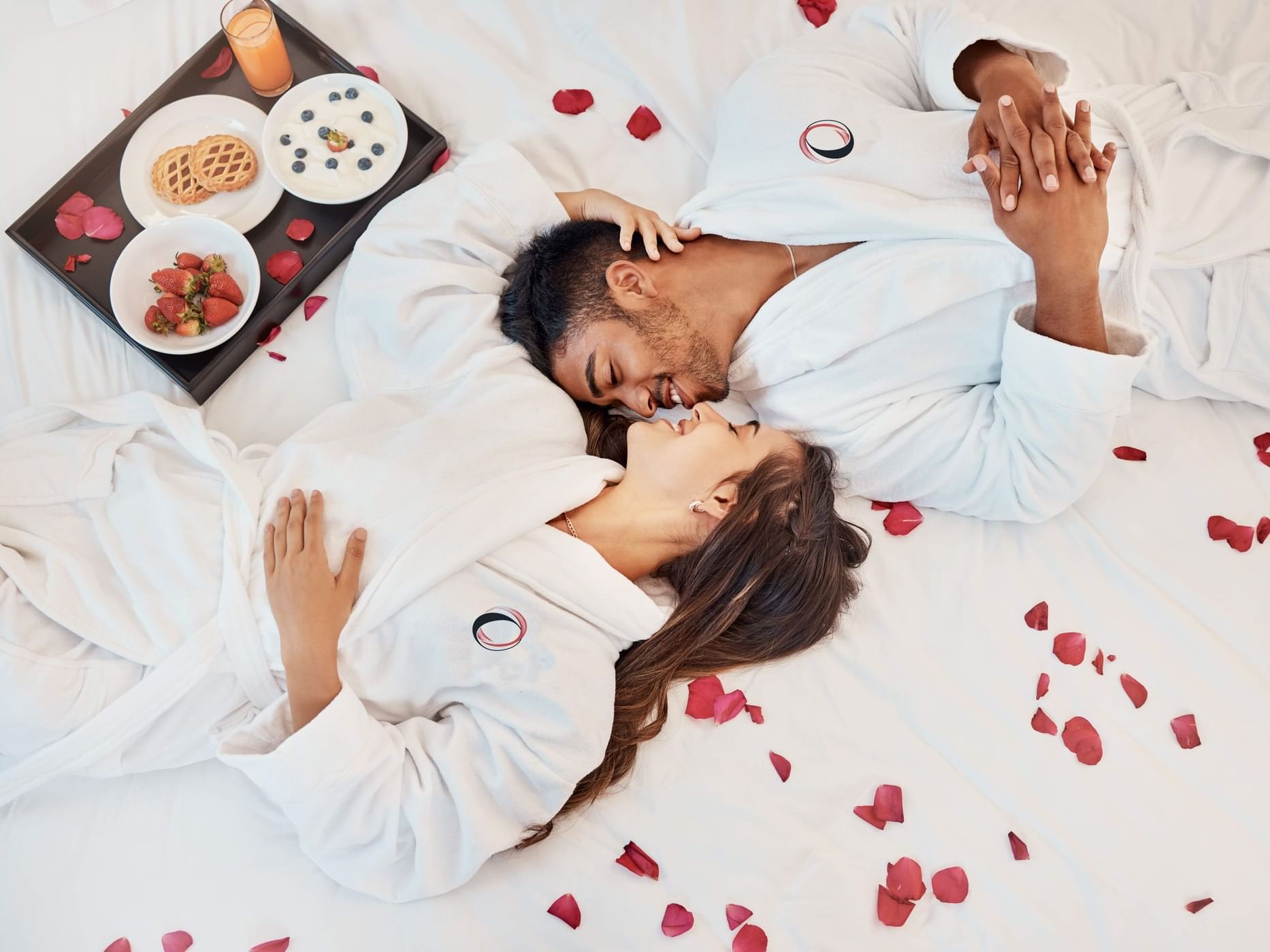 Romantic Experience offer featuring couple laying on the bad at The Originals City, Hotel Bristol