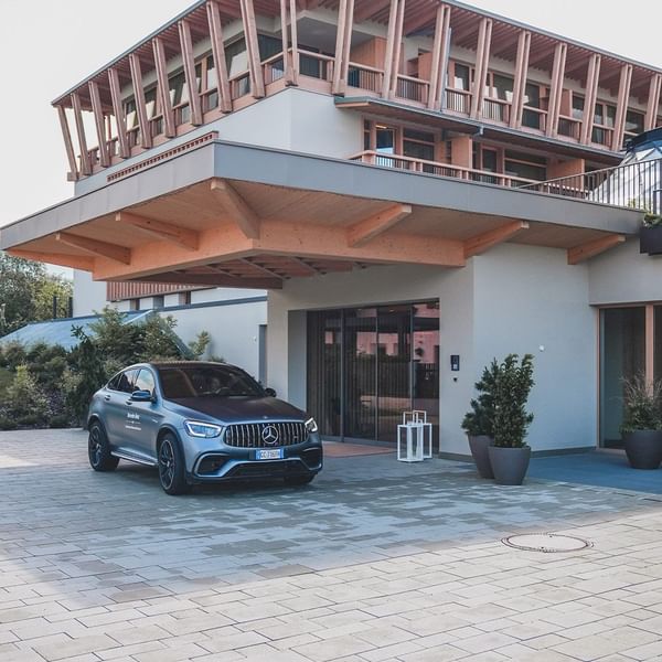 Luxury Mercedes SUV parked in front of Falkensteiner Hotel Kronplatz with wooden features