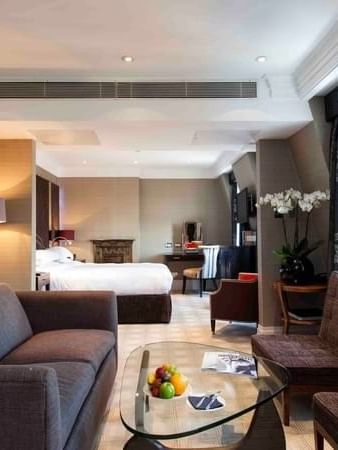 Townhouse Junior Suite living area with plush sofa near bed at The Capital Hotel, Apartments and Townhouse