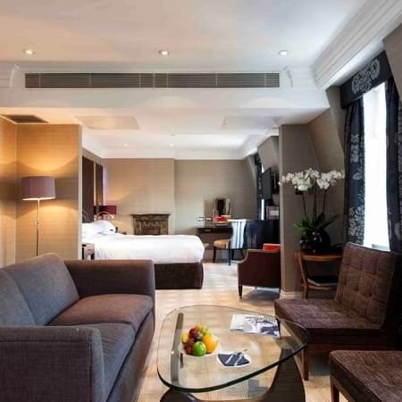 Townhouse Junior Suite living area with plush sofa near bed at The Capital Hotel, Apartments and Townhouse