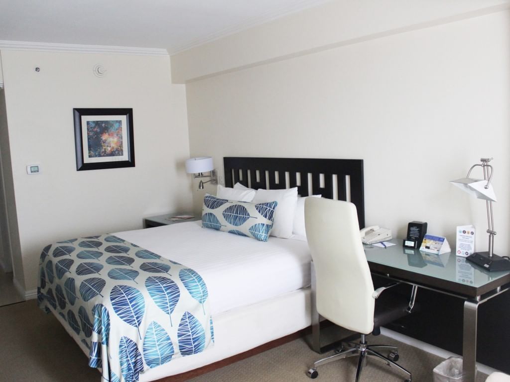 King bed, workspace & nightstand in Deluxe Room at Jamaica Pegasus Hotel