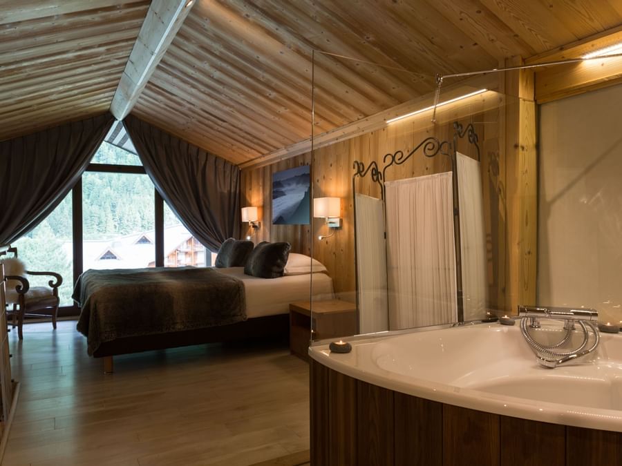 A bedroom with a Jacuzzi pool at Chalet-Hotel La Chemenaz