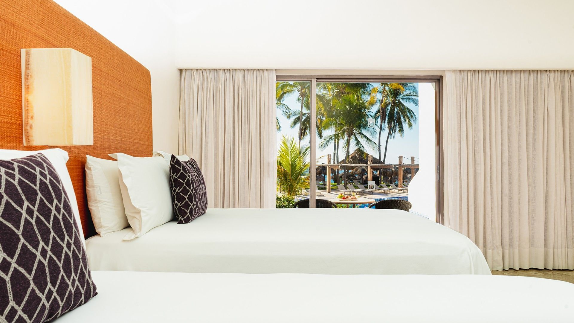 Two Double Deluxe Private Pool Room interior with cozy beds and cushioned headboard at Camino Real Zaashila Huatulco