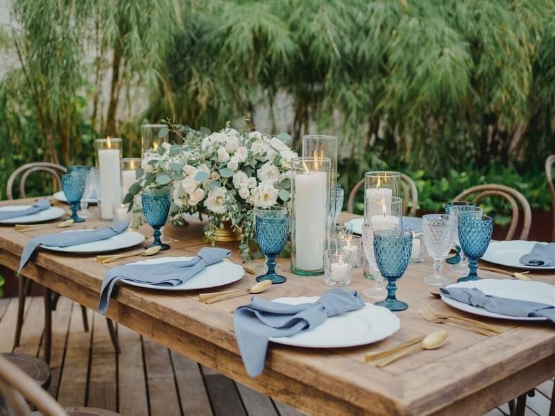 Arranged outdoor dining table with flower décor and candles at The Explorean Cozumel
