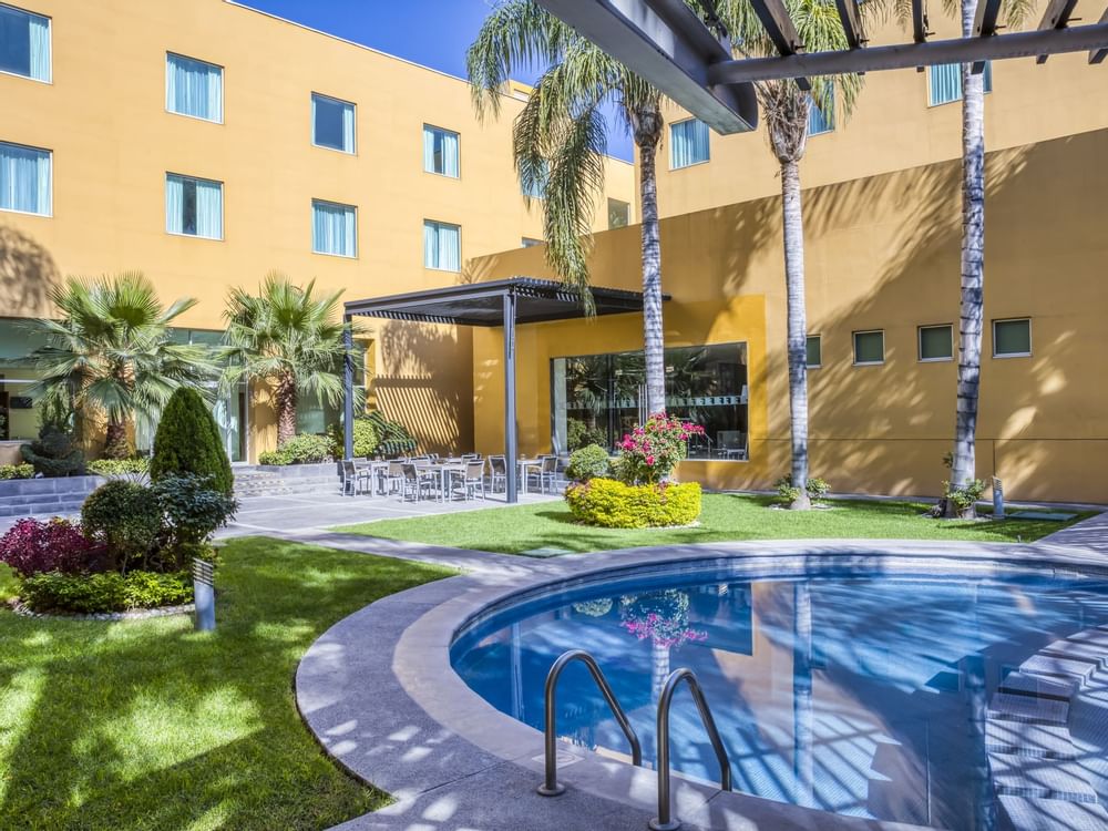 Outdoor swimming pool with Hotel garden view at Fiesta Inn