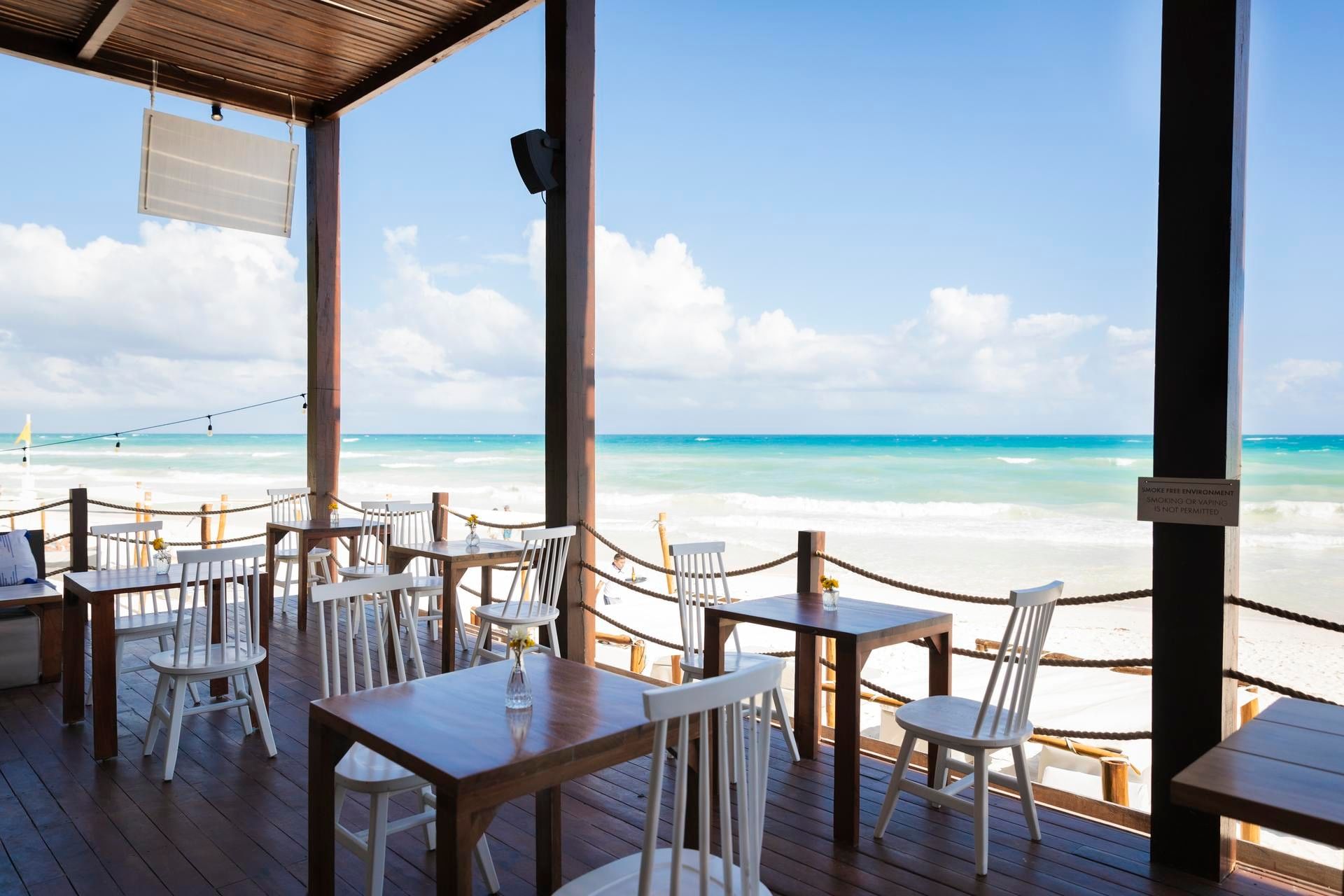 Open-air dining tables looking directly onto the beach at La Zebra