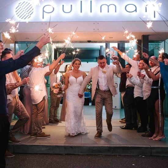 Couple with Elegant wedding sparklers lighting up at Pullman Magenta Shores