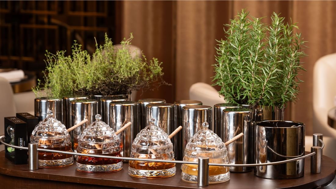 A collection of honey jars and fresh herbs, part of a breakfast or buffet setup at Sunway Hotel Pyramid