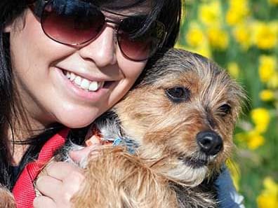 girl with black hair holding dog