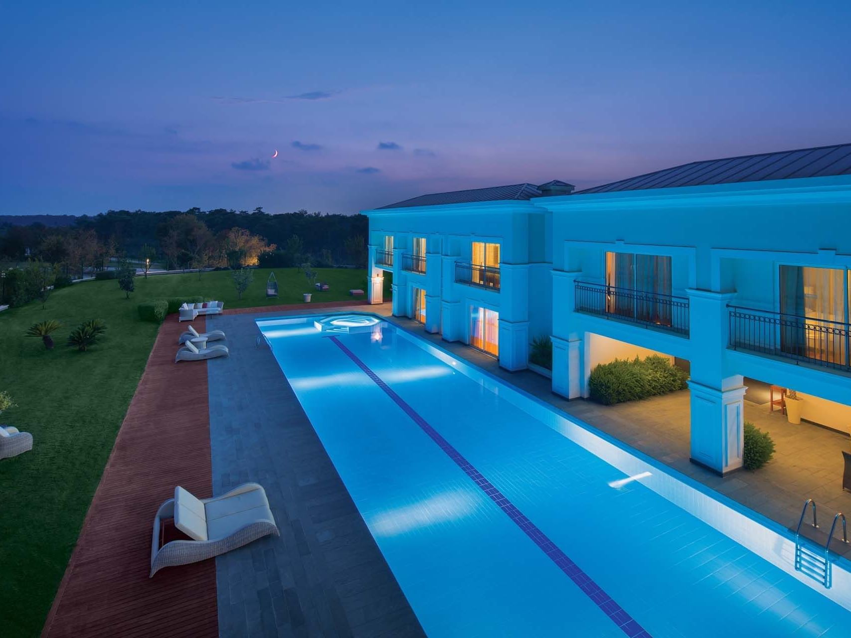 Aerial view of an outdoor pool facing Presidential Villa in Titanic Deluxe Golf Belek at night