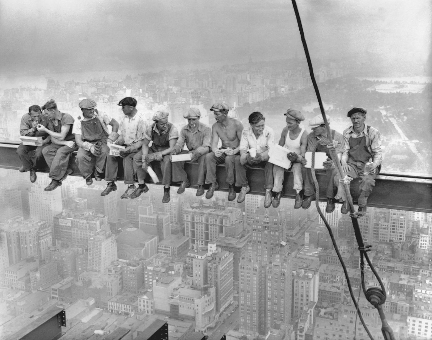 Eleven workers sitting on a steel beam overlooking a cityscape at Warwick Corporate
